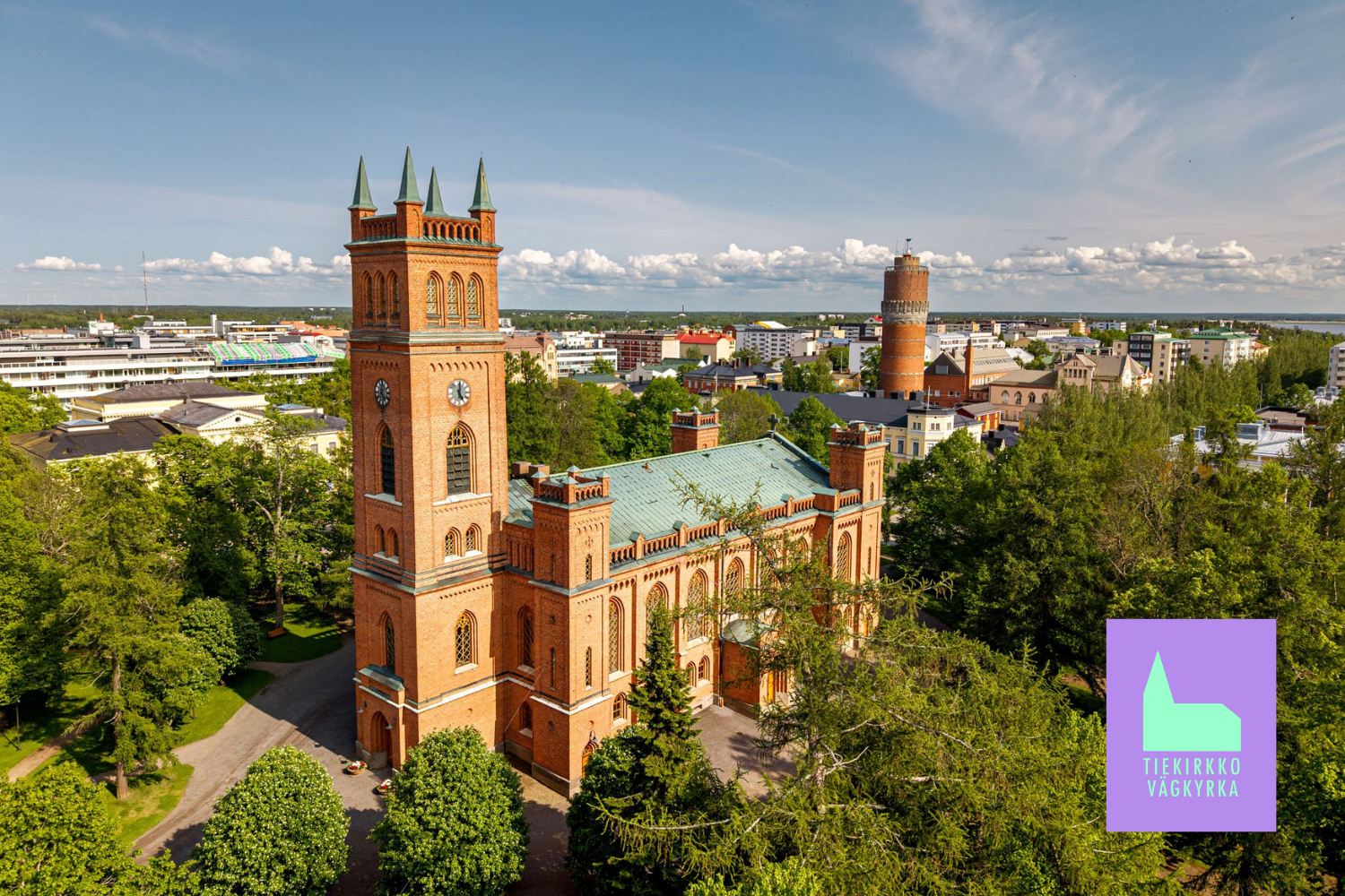 Punainen iso tiilikirkko. Teksti: Tiekirkko, vägkyrka.