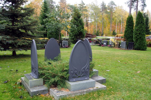 Kuvassa on neljän uurnan hautoja, joissa on muistomerkki valmiina.