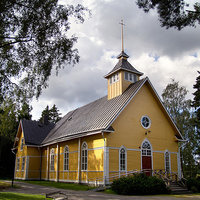 Sundomin kirkko Keltainen puukirkko, jossa tummaruskea peltikatto